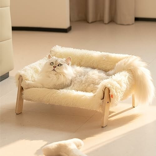 White cat lounging on a fluffy bed.